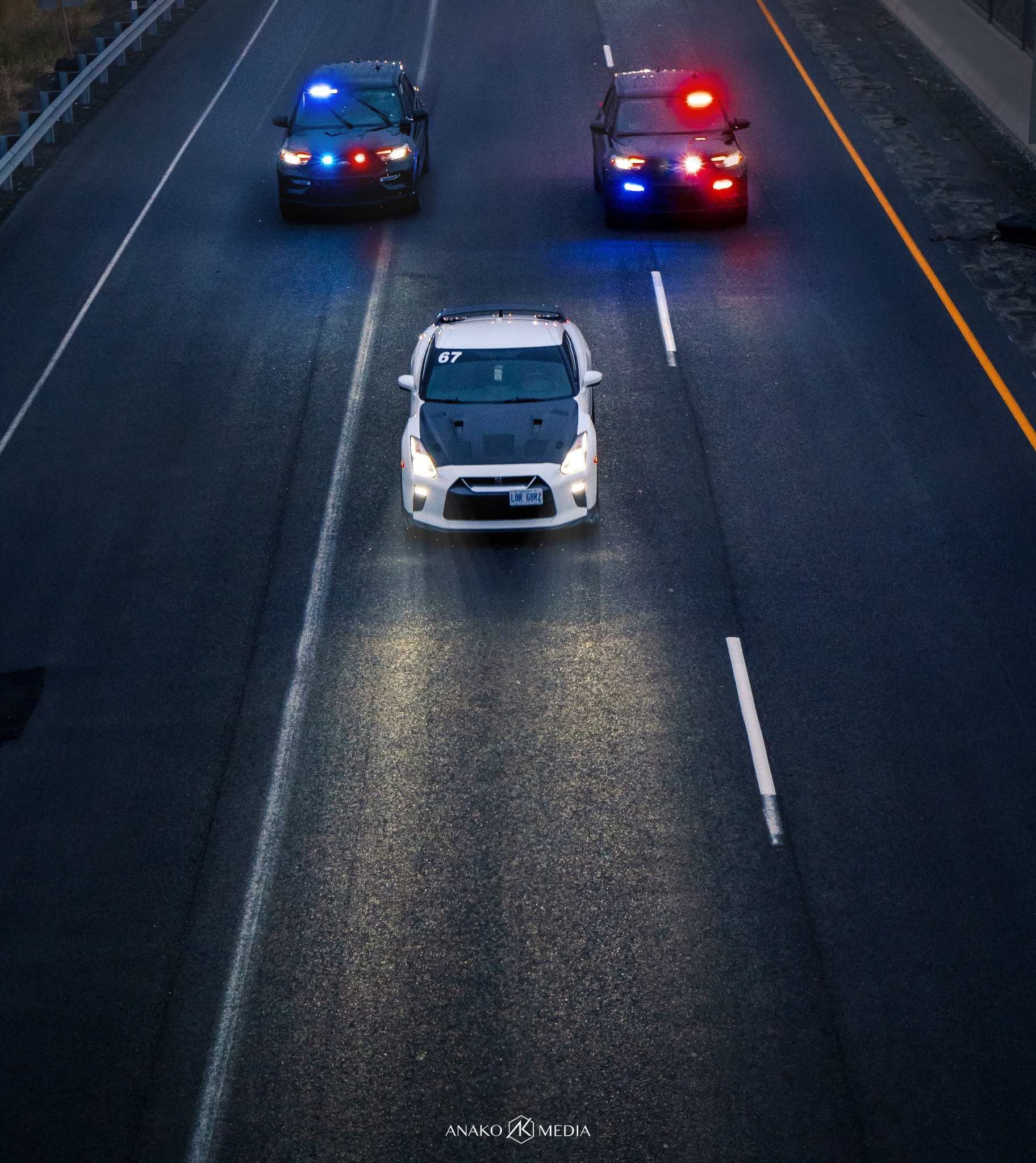 White Nissan GT-R R35 on the road with police vehicles behind it